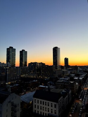 A cityscape at dusk with high-rise buildings and a street below. - Cozy 1-bedroom apartment in gorgeous Jersey City with AC and gym access (Jersey City)