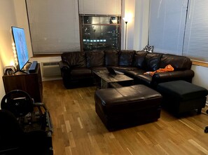 Ein Wohnzimmer mit Ledersofa, Couchtisch und Fernseher.