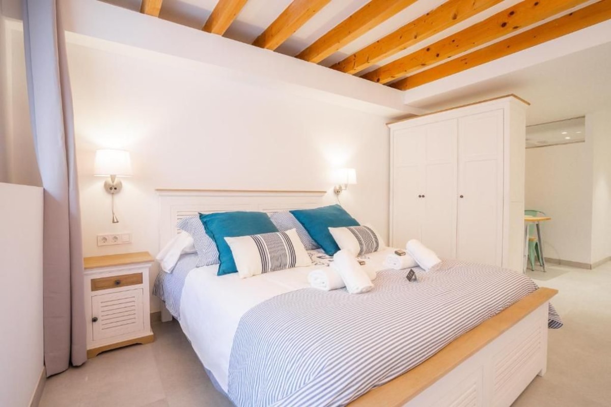 A bedroom with a bed, bedside tables, a wardrobe, and a lamp.