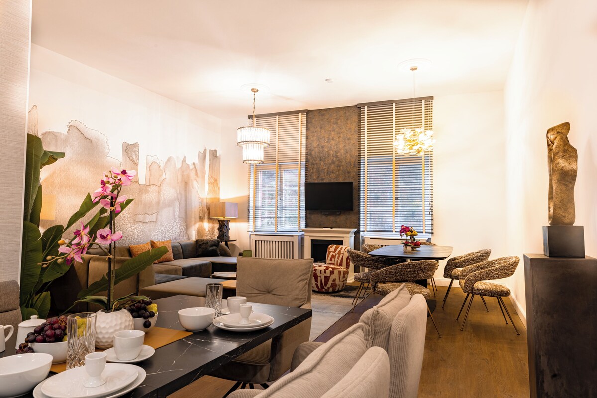 Una sala de estar moderna con comedor, chimenea y televisor.