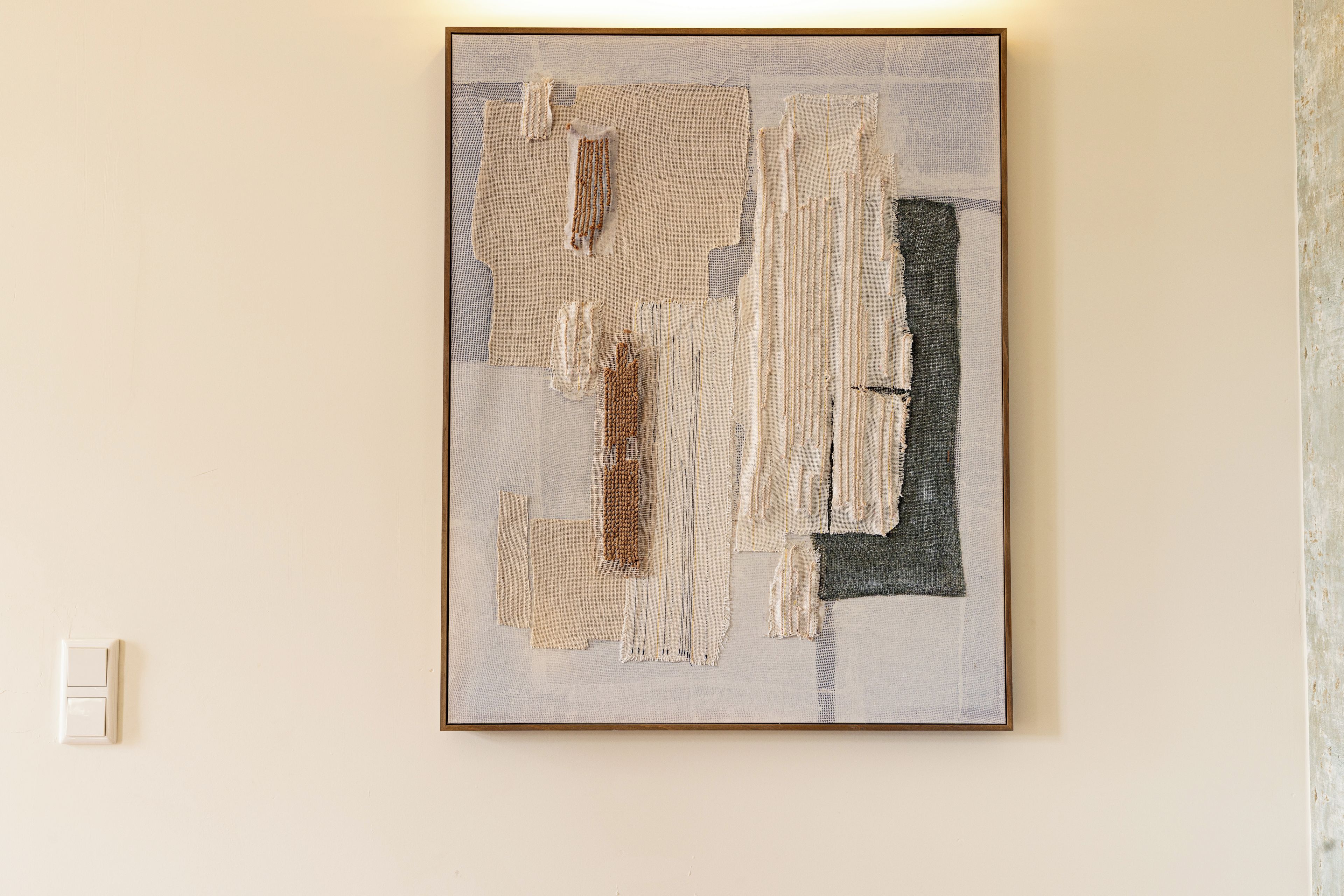 A framed abstract art piece on a wall.