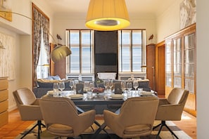 Comedor con una mesa grande dispuesta para seis personas, rodeada de seis sillas.