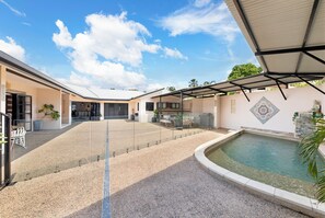 Ett takförsett utomhusområde med en pool, sittplatser och en klar himmel.