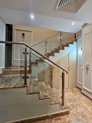Eine moderne Treppe mit Glastrennwand und Holzboden.