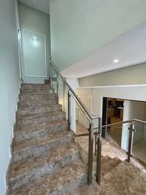 A staircase with marble steps and metal railings leading to an upper floor. - Spacious 4-bedroom townhome in Damac hills 2 in enjoyable Dubai (Dubai)