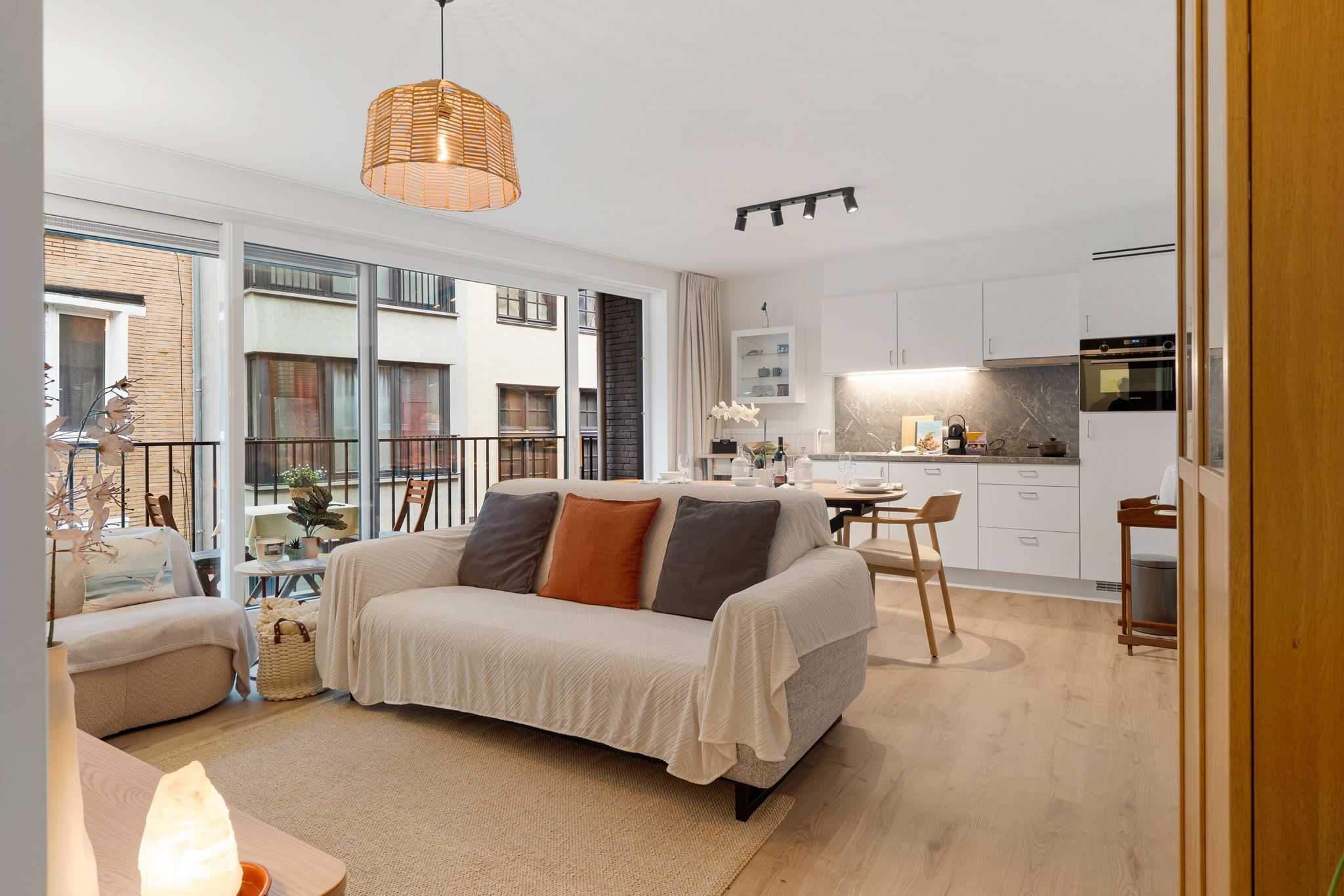 Een modern appartement met een groot bed, een eethoek en een keuken.
