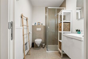 Ein modernes Badezimmer mit Dusche, Toilette und Waschtisch.