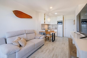 Eine moderne Wohnung mit Wohnbereich, Küchenzeile und Essplatz.