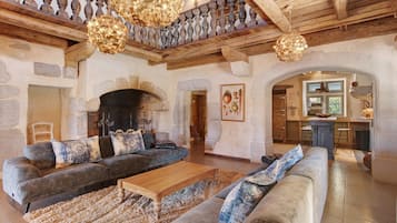 Un intérieur rustique avec une cheminée en pierre, des poutres en bois et un coin repas.