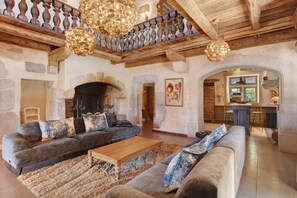 A rustic interior with a stone fireplace, wooden beams, and a dining area. - Château 'Le Chateau Des Girards' authentically renovated (Lans-en-Vercors)