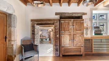 Un intérieur rustique avec des murs en briques apparentes, des poutres en bois et une porte en bois traditionnelle.