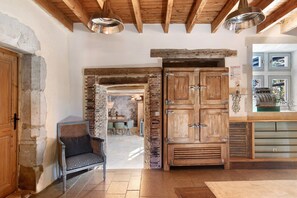 A rustic interior with exposed brick walls, wooden beams, and a traditional wooden door. - Château 'Le Chateau Des Girards' authentically renovated (Lans-en-Vercors)