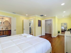 A bedroom with a large bed, a walk-in closet, and a bathroom with a vanity. - Charming Tampa retreat with a private hot tub (Tampa)