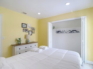 A bedroom with a bed, dresser, and a closet with hangers. - Charming Tampa retreat with a private hot tub (Tampa)