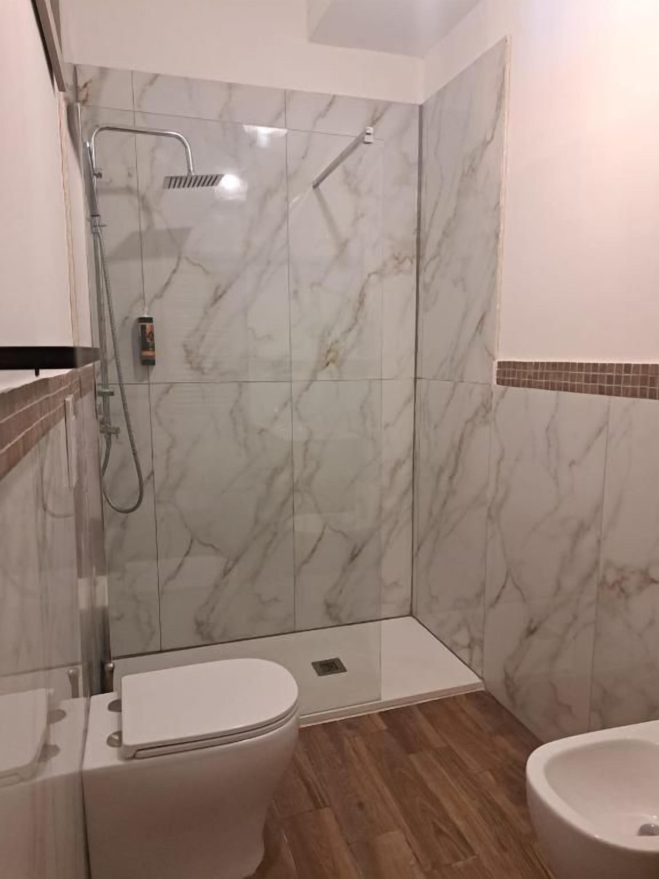 Ein Badezimmer mit Dusche, Toilette und Bidet.