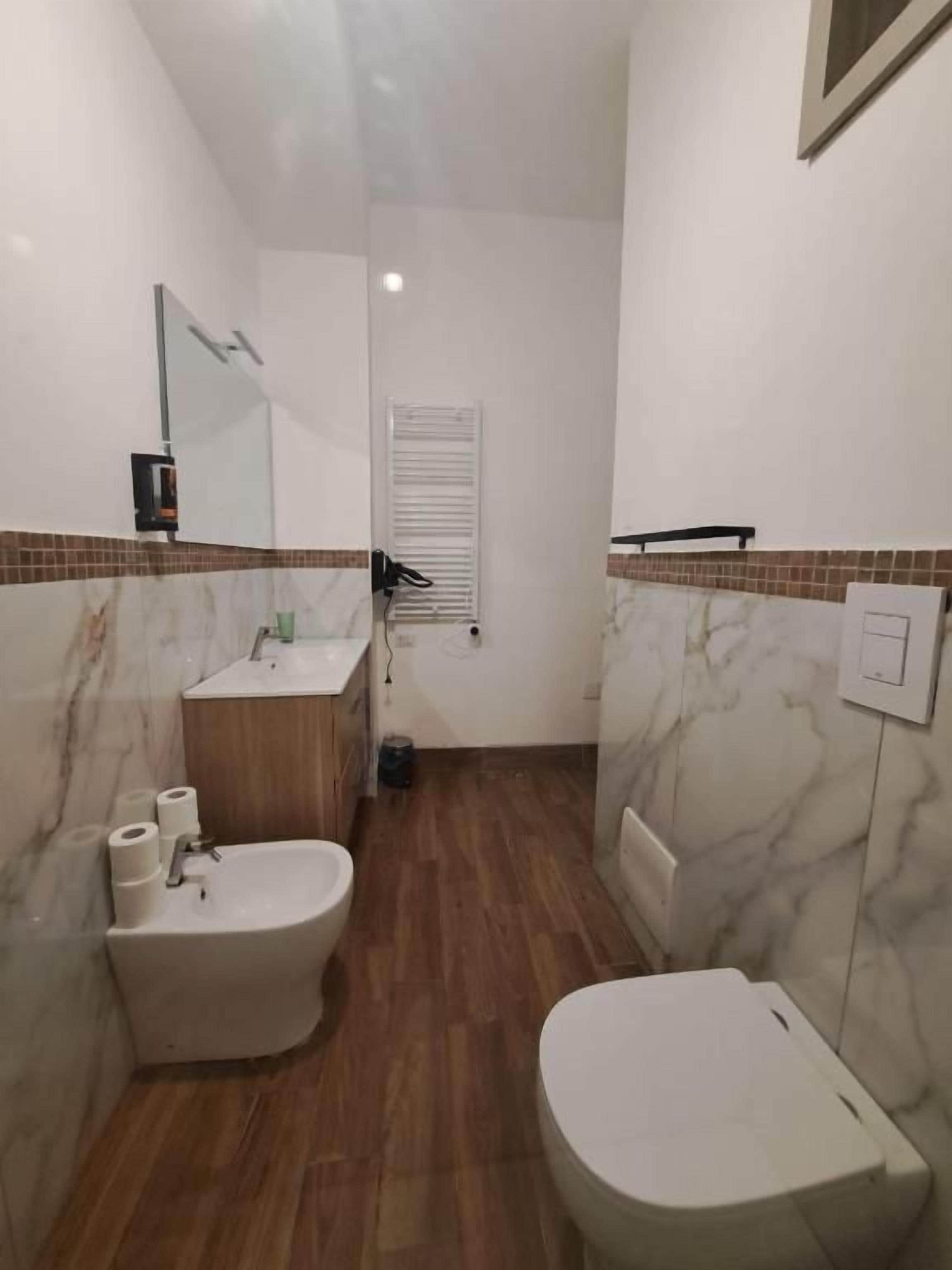A bathroom with a toilet, bidet, and sink.
