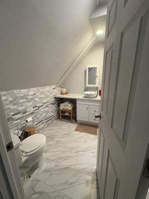 Une salle de bain avec des toilettes, un lavabo et un miroir.