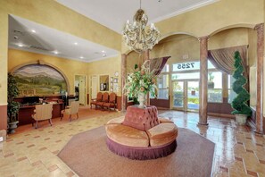 A lobby with a round seating area, a reception desk, and a large chandelier. - Tuscano Condo Gem! SW Las Vegas Oasis (Las Vegas)