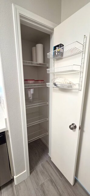 A walk-in closet with multiple shelves and storage bins. - Tuscano Condo Gem! SW Las Vegas Oasis (Las Vegas)
