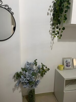 A bathroom with a mirror, a potted plant, and a shelf with a mug and picture frames. - Apartment 'La Casa Di Kya - Universo Beach' with Sea View, Wi-Fi and Air Conditioning (Salerno)