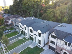 A residential building with a flat roof, multiple windows, and a garage. - 5BD High Park Retreat w/ Home Theatre, Game Room & Deck (Toronto)