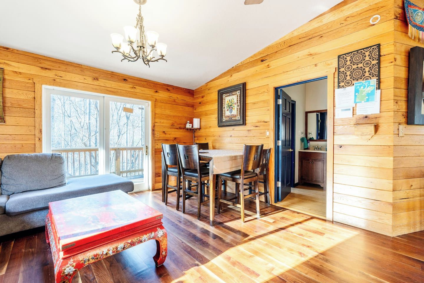 Un intérieur en bois comprenant un coin repas, un canapé et une table avec des chaises.