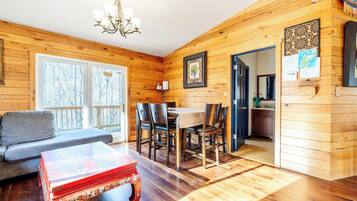 Un intérieur en bois comprenant un coin repas, un canapé et une table avec des chaises.