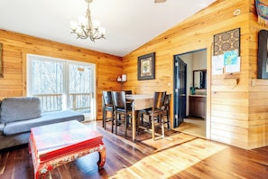 A wooden interior with a dining area, a sofa, and a table with chairs. - Secluded Mountain Master Suite with Sauna & Jacuzzi (Hot Springs)