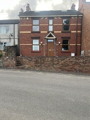 A two-story brick house with a central door, windows on each floor, and a small porch area. - Cheshire View 4 Beds House close to Wrexham City Centre (Summerhill)