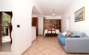 A compact living space with a dining area, kitchenette, and a sofa. - Essences of the Mediterranean by Espresso Rentals (Termini)