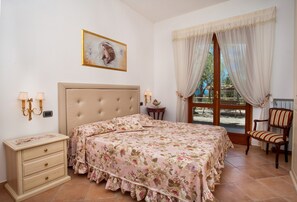 A bedroom with a bed, bedside tables, a chair, a window with curtains, and a painting on the wall. - Villa Rosanto by Espresso Rentals (Arenaccia)