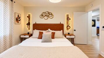 Un dormitorio moderno con una cama grande, mesitas de noche y decoración mural.