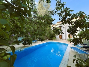 A swimming pool surrounded by greenery and a building with a tiled roof. - Limoneto - Combo by Espresso Rentals (Massa Lubrense)