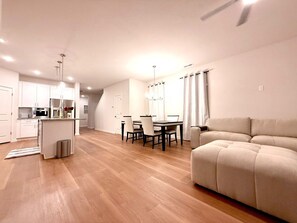 A modern living space with a kitchen, dining area, and a sofa. - NEW - 8Beds 16People (Durham)