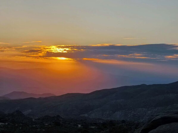 Een bergachtig landschap met een zonsondergang.
