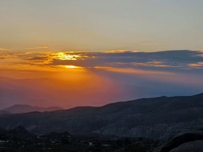 A mountainous landscape with a sunset.