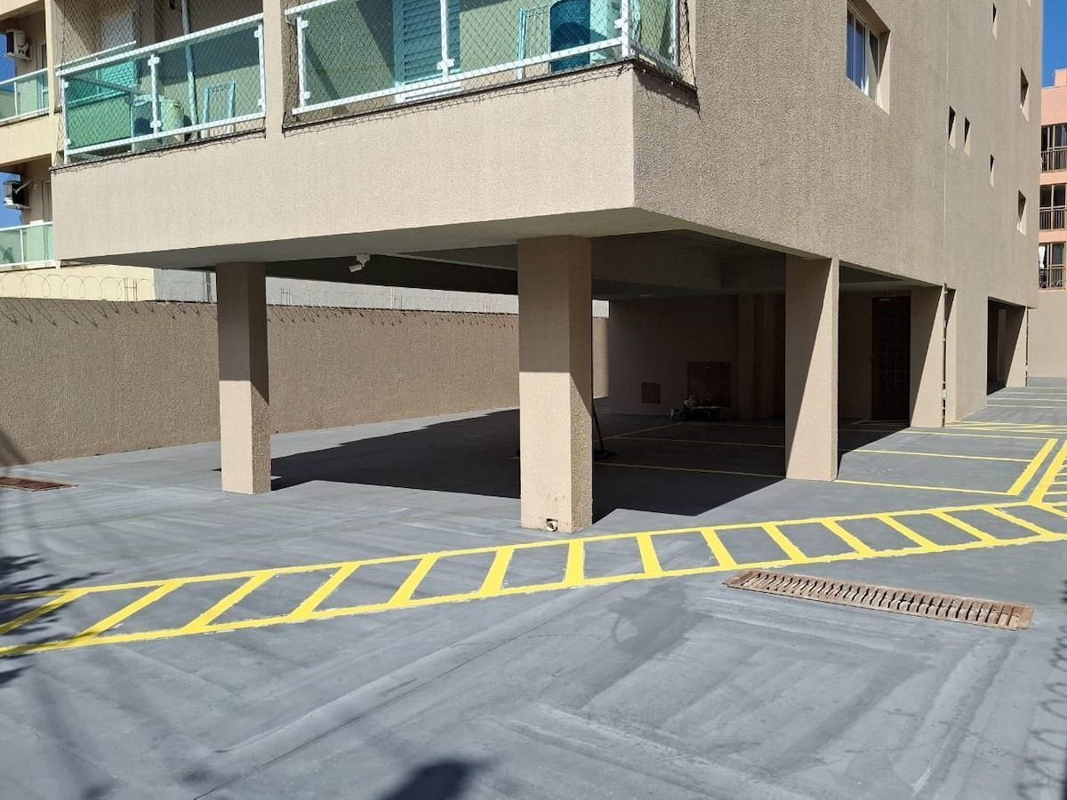 A parking area with yellow lines and a drainage grate.