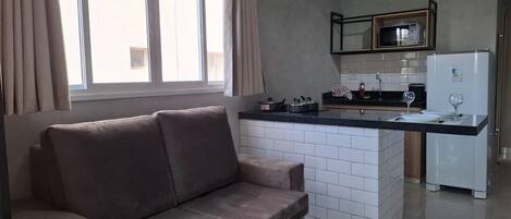 Un espace de vie comprenant un canapé et un îlot de cuisine.