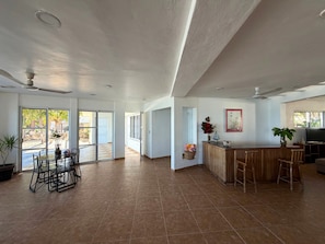 Un espacio habitable amplio con cocina, comedor y ventanas grandes.