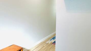 A hallway with a wooden bench, a coat rack, and a patterned rug on the floor.