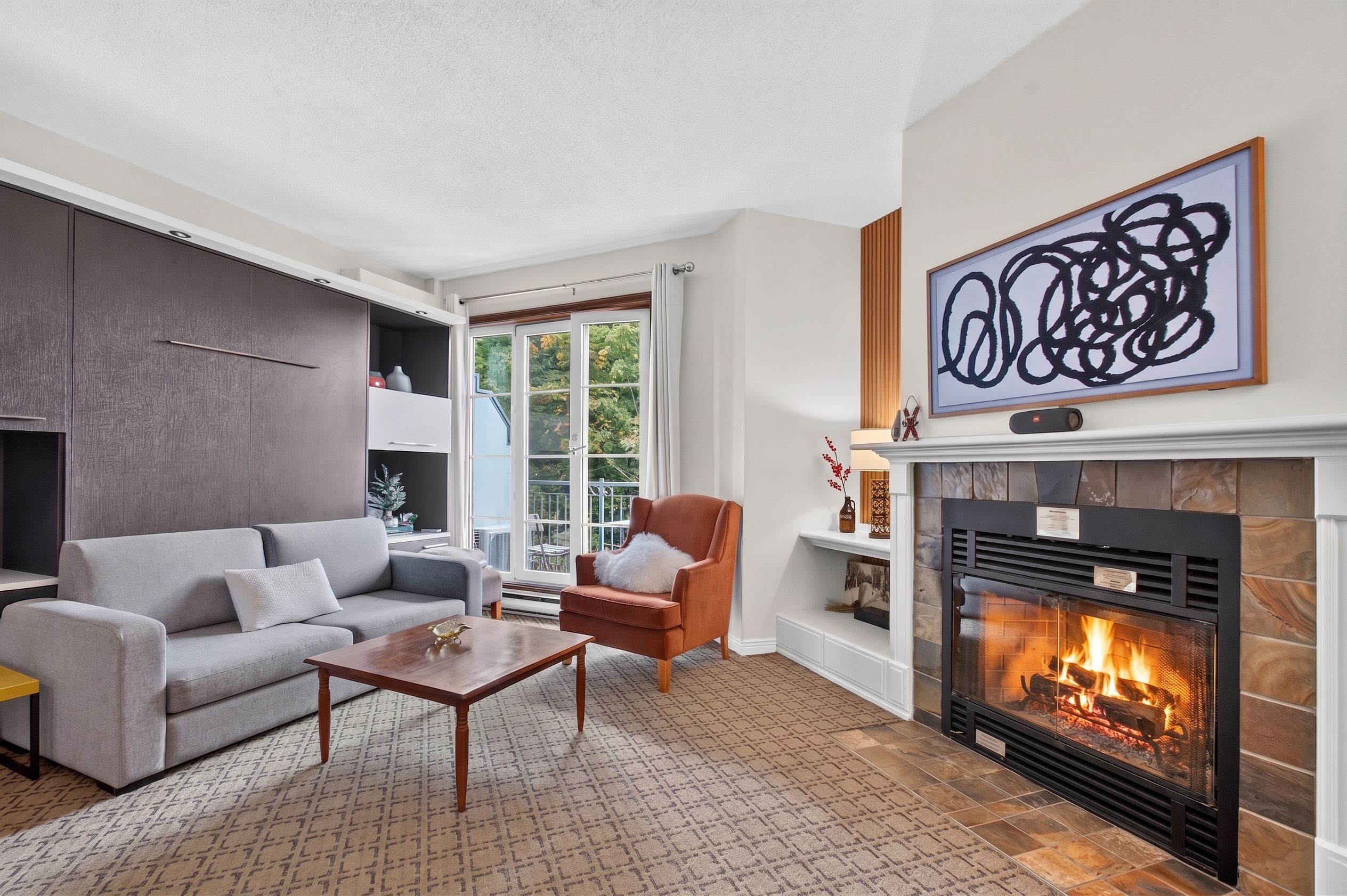 A living room with a fireplace, a sofa, a coffee table, and a chair.