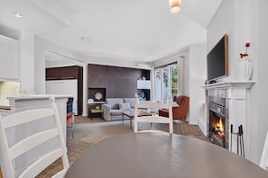 A modern living room with a fireplace, a television, and a dining area. - Johannsen 359 (Mont-Tremblant)