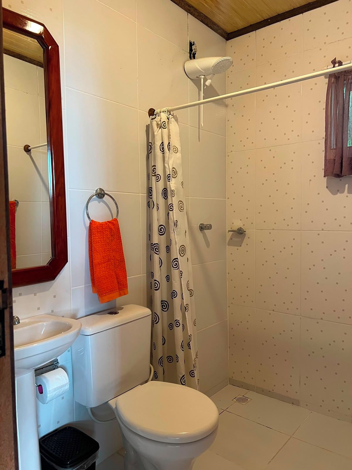 Ein Badezimmer mit Toilette, Waschbecken und Duschbereich.