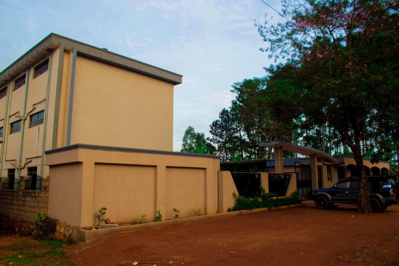 A building with a flat facade, a gated entrance, and a parked vehicle.