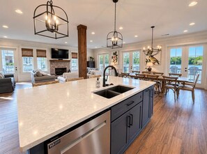 A spacious kitchen with a large island, modern appliances, and a dining area with wooden furniture.