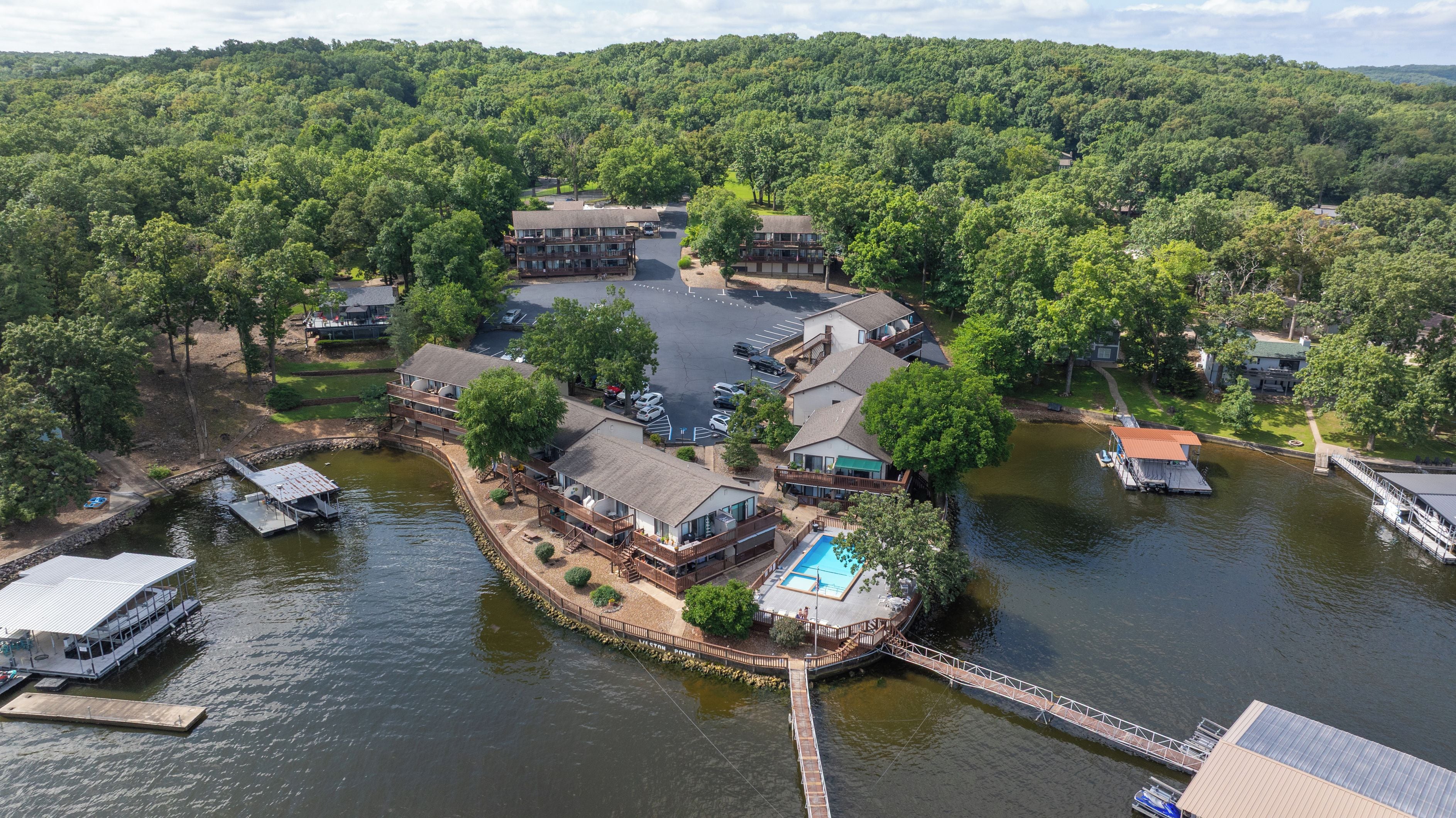 A lakeside property with multiple buildings, a dock, and a swimming area.