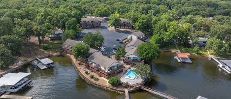 A lakeside property with multiple buildings, a dock, and a swimming area.