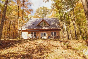 A cabin with a gabled roof, large windows, and a porch with outdoor seating. - Cozy Cabin Cottage on Big Gull Lake Waterfront (North Frontenac)