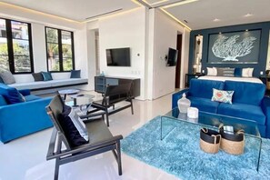 Ein modernes Wohnzimmer mit einer Couch, einem Couchtisch und einem Fernseher.