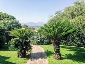 Un sendero en un jardín que conduce a una vista panorámica con montañas al fondo.